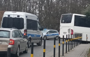 Zdjęcie przedstawiające policjantów radiowóz pilotujący samochody.