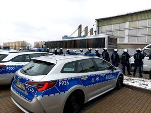 Zdjęcie przedstawiające policjantów oraz radiowozy.