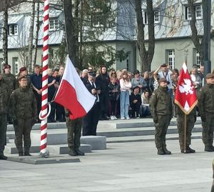 Zdjęcie przedstawiające uczestników i moment podnoszenia flagi na maszt.