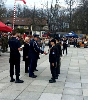 Zdjęcie przedstawiające Pana Komendanta wreczającego gratulacje wyznaczonym uczniom.