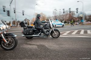 Zdjęcie przedstawiające uczestników rozpoczęcia sezonu oraz oraz policjanta na skrzyżowaniu.