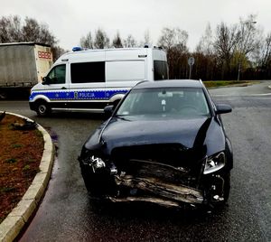 Zdjęcie przedstawiające dwa samochody uczestniczące w zdarzeniu drogowym oraz samochód policyjny.