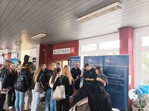 Zdjęcie przedstawiające policjantów oraz zebrane osoby przy stoisku.
