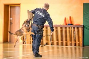 Zdjęcie przedstawiające policjanta i psa służbowego.