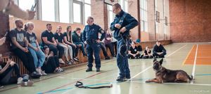 Zdjęcie przedstawiające policjantów oraz psa służbowego w trakcie pokazu.