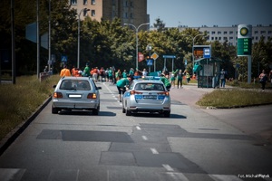 Zdjęcie przedstawiające radiowóz ruchu drogowego na trasie biegu.