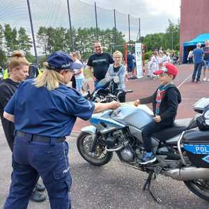 Zdjęcie przedstawiające policjantkę oraz chłopca na motocyklu.