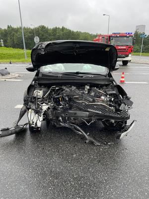 zdjęcie przedstawiające uszkodzony czarny samochód biorący udział z zdarzeniu drogowym