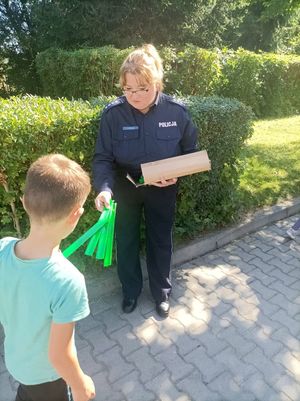 Zdjęcie przedstawiające policjantkę wręczającą odblask.