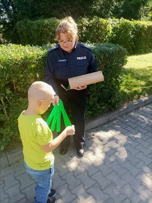 Zdjęcie przedstawiające policjantkę w momencie wręczania odblasku.