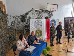 Zdjęcie przedstawiające moment podpisania porozumienia przez Pana Komendanta i Panią Dyrektor.