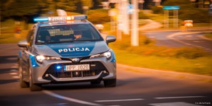 Zdjęcie przedstawiające policjanta oraz radiowóz w trakcie zabezpieczenia.