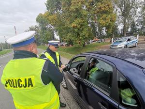 Zdjęcie przedstawiające policjantów ruchu drogowego rozmawiających z kierowcą.