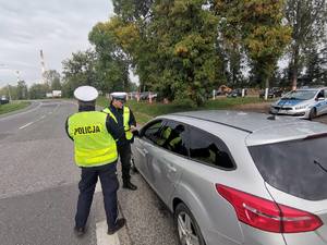 Zdjęcie przedstawiające policjantów ruchu drogowego w trakcie rozmowy z kierowcą.