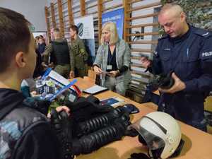 Zdjęcie przedstawiające policjanta oraz kadrową w trakcie rozmowy z zainteresowanymi.