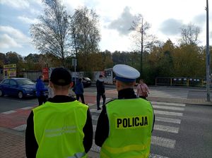 Zdjęcie dwóch policjantów przy cmentarzu.
