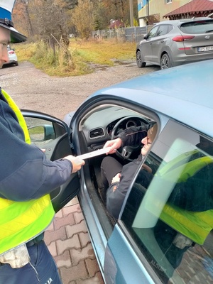 Zdjęcie przedstawiające policjanta wręczającego odblaski.