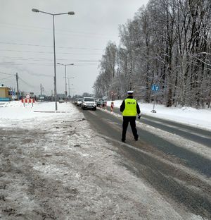 Zdjęcie policjanta w trakcie badania stanu trzeźwości kierowcy.