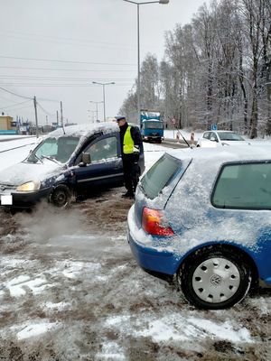 Zdjęcie policjanta w trakcie badania stanu trzeźwości kierowcy.