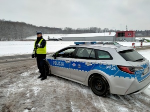 Zdjęcie policjanta w trakcie badania stanu trzeźwości kierowcy.