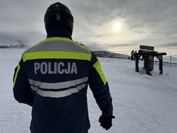 Zdjęcie policjanta na tle góry.