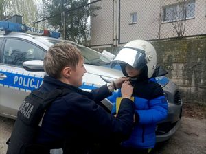Zdjęcie Kacperka z założonym kaskiem i policjantki.