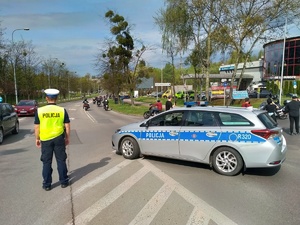 Zdjęcie przedstawiające policjanta zabezpieczającego przejazd motocyklistów.