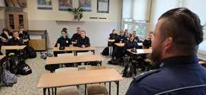 Zdjęcie przedstawiające policjanta oraz uczniów klasy pożarniczej.