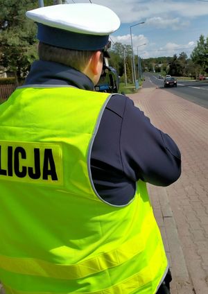 Zdjęcie policjanta ruchu drogowego wykonującego badanie prędkości.