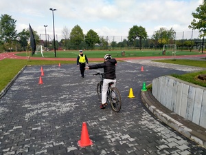 Zdjęcie przedstawiające policjanta oraz ucznia, który zatrzymał się w związku z znakiem stop.