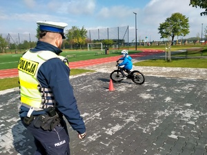 Zdjęcie przedstawiające policjanta oraz ucznia, który pokonuje tor jazdy.