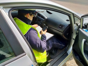 Zdjęcie policjanta wypisującego mandat.