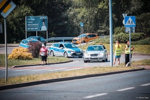 Zdjęcie przedstawiające radiowozy ruchu drogowego zabezpieczające wyścig.