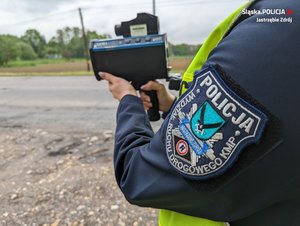 Zdjęcie policjantki trzymającej urządzenie do pomiaru prędkości.