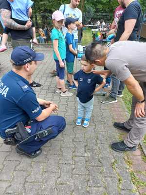 Zdjęcie przedstawiające policjanta rozmawiającego z dzieckiem.