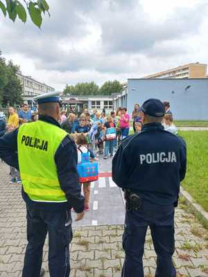 Zdjęcie przedstawiające dwóch policjantów oraz uczniów.