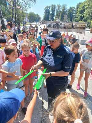 Zdjęcie przedstawiające policjantkę, rozdającą odblaski.