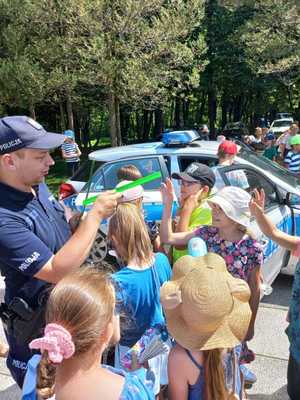 Zdjęcie przedstawiające policjanta rozdającego odblaski.