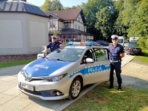 Zdjęcie przedstawiające policjantów oraz radiowóz.