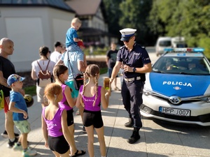 Zdjęcie przedstawiające policjanta rozdającego odblaski.