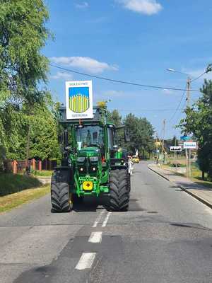 Zdjęcie przedstawiające traktor jadący w korowodzie.