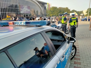 Zdjęcie przedstawiające policjantów oraz radiowóz.