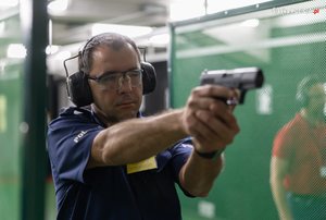 Zdjęcie policjanta celującego z broni.