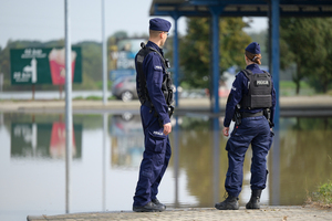 Zdjęcie policjanta i policjantki stojących przy zbiorniku wodnym.