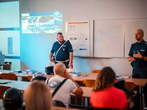 Zdjęcie przedstawiające dwóch policjantów oraz uczestników spotkania.