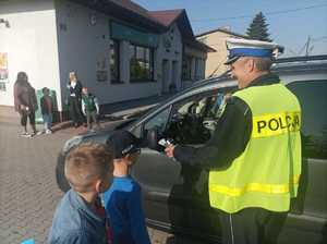 Zdjęcie przedstawiające policjanta, który bada trzeźwość kierowcy.