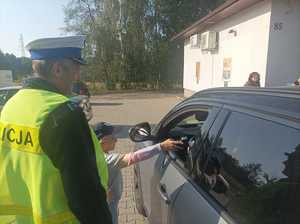 Zdjęcie przedstawiające dziecko, które bada stan trzeźwości w obecności policjanta.