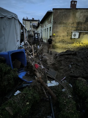 Zdjęcie przedstawiające uszkodzone rzeczy znajdujące się na drodze po powodzi.