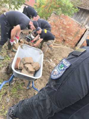 Zdjęcie przedstawiające policjantów sprzątających gruz.