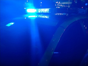 Zdjęcie radiowozu z włączonymi sygnałami świetlnymi.